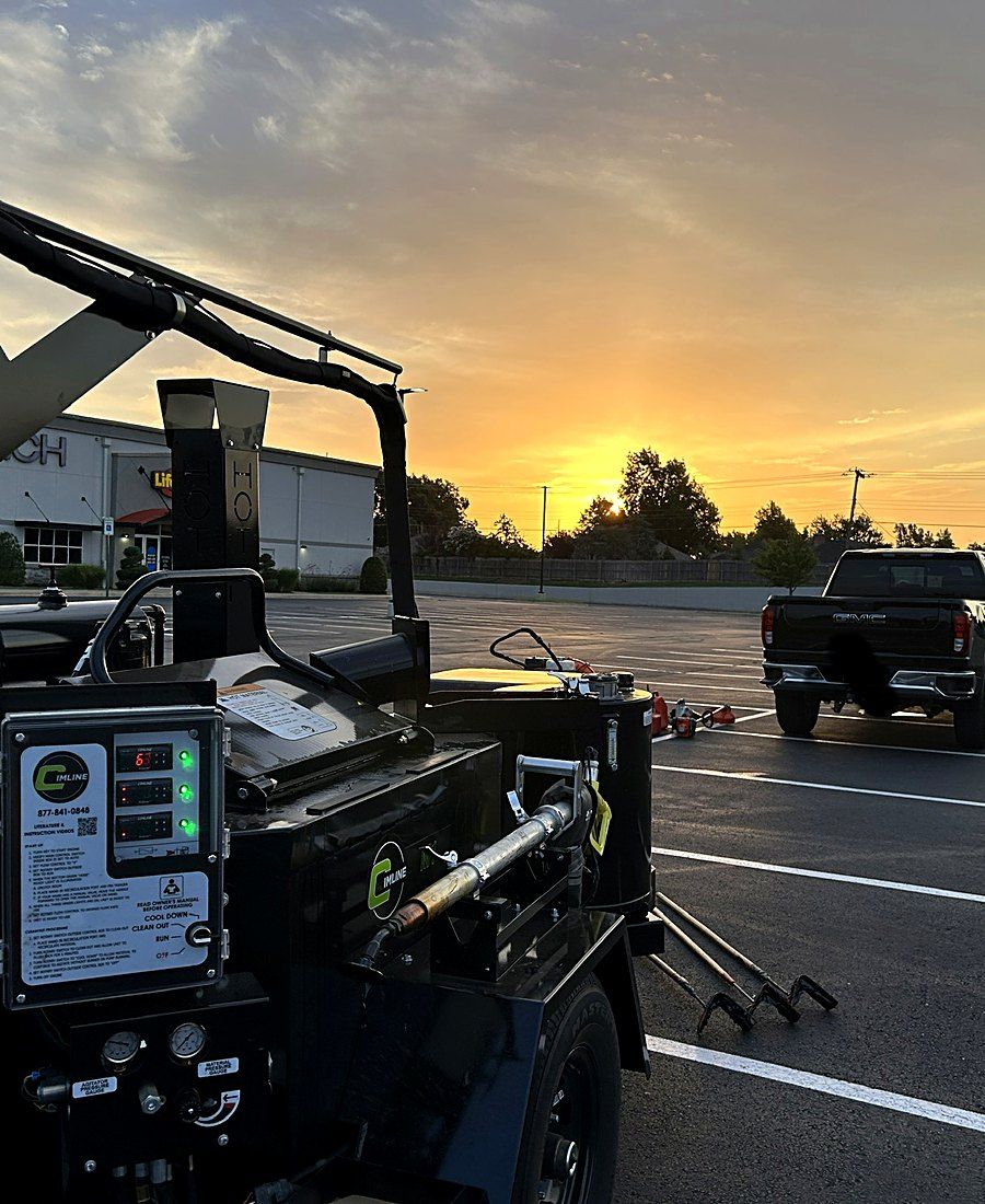 Heartland crack sealing rig and truck working a lot at sunset