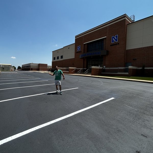 Crew member inspecting fresh striping at a commercial property